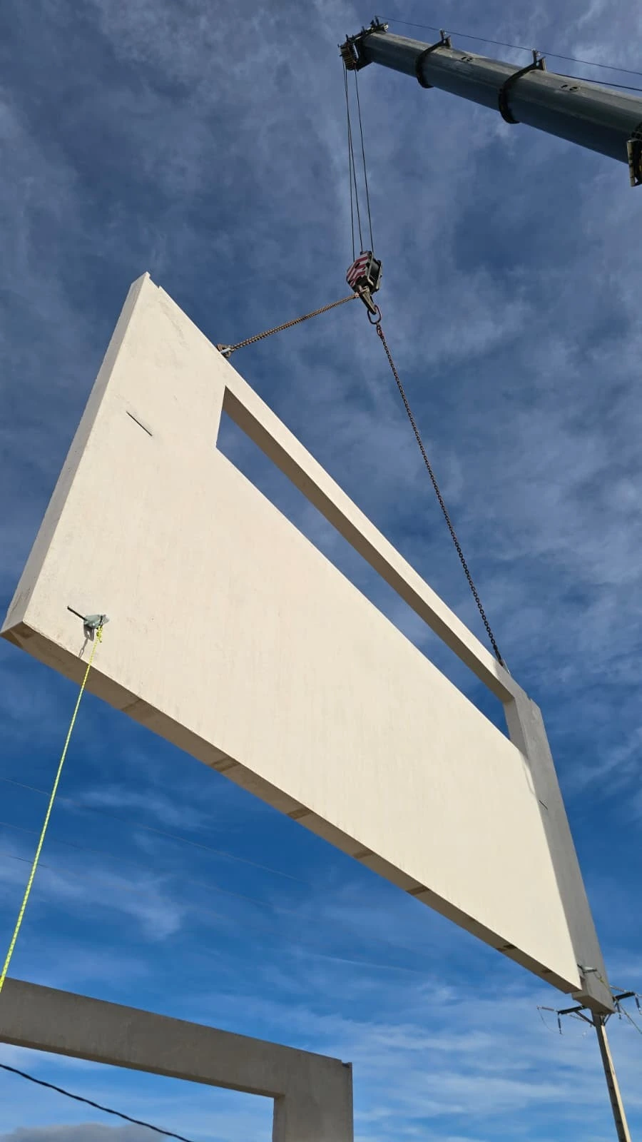 Panel de hormigón suspendido de una grúa durante el montaje en ETAP L’Ampolla